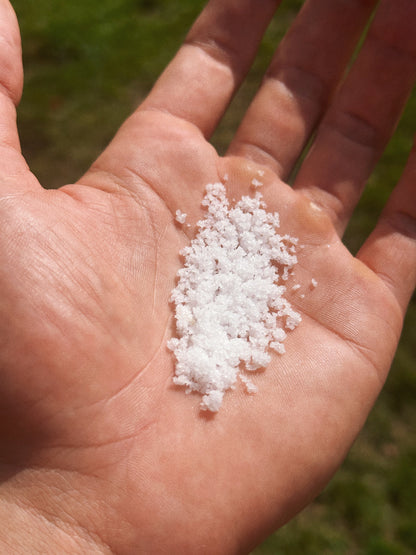 handful of sol brah's hydration salts in front of grass